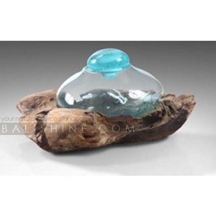 Balishine: Your natural source of indonesian handicraft presents in its Home Decor collection the Handmade Blown Glass 1 Bowl with Teak Wood Stand:12INT878052:Beautiful root teak wood is reminiscent of jagged rocks, while the clear handblown crystal takes on the nature of the tides for an eye-catching decorative piece that is the perfect addition to your home.  This piece include 1 pc bowl made from handmade blowing glass with glass stopper. Because each bottle is handmade, shape and size can vary slightly and tiny bubbles may appear within the glass. This exemplifies the hand-blown technique, making every piece a unique example of blown glass craftsmanship.