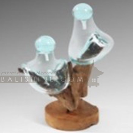 Balishine: Your natural source of indonesian handicraft presents in its Home Decor collection the Handmade Blown Glass 2 Bottles with Teak Wood Stand:12INT878050:Beautiful root teak wood is reminiscent of jagged rocks, while the clear handblown crystal takes on the nature of the tides for an eye-catching decorative piece that is the perfect addition to your home.  This piece include 2 pcs bottles made from handmade blowing glass diameter 20 cm with glass stopper. Because each bottle is handmade, shape and size can vary slightly and tiny bubbles may appear within the glass. This exemplifies the hand-blown technique, making every piece a unique example of blown glass craftsmanship.